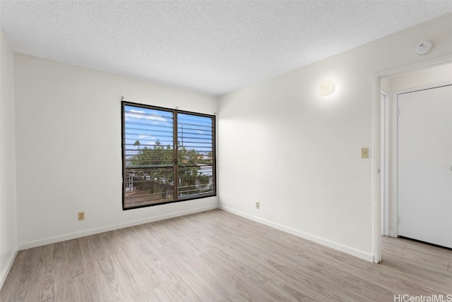 empty room featuring light hardwood / wood-style floors and a textured ceiling