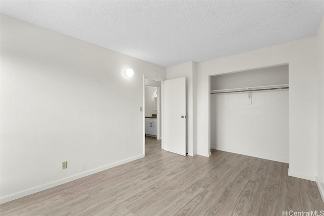 unfurnished bedroom featuring a textured ceiling, a closet, and light wood-type flooring