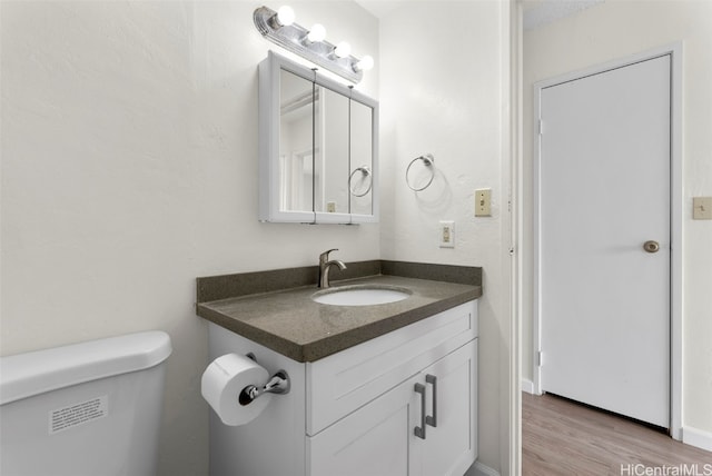 bathroom featuring vanity, toilet, and wood-type flooring