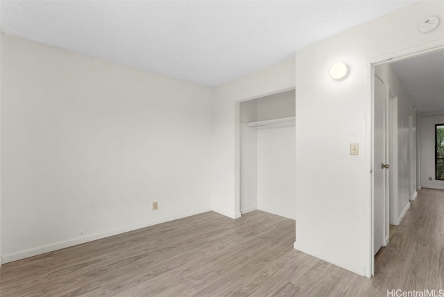 unfurnished bedroom featuring light wood-type flooring and a closet