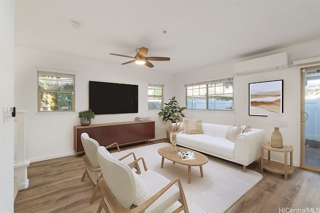 living room with wood-type flooring, a wall unit AC, and ceiling fan