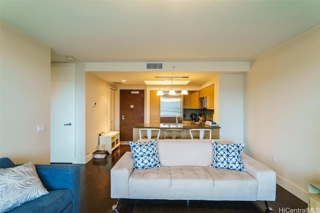 living room featuring dark hardwood / wood-style flooring and sink