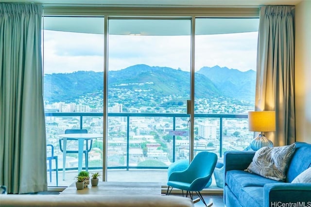 living room featuring baseboard heating, a mountain view, and a wealth of natural light