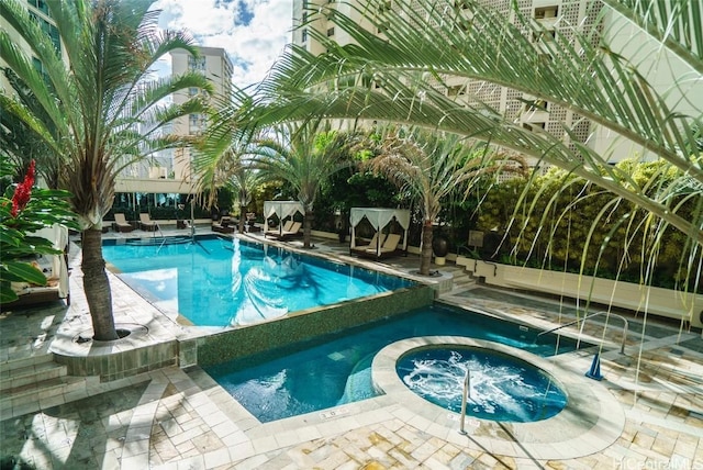 view of swimming pool with an in ground hot tub and a patio area