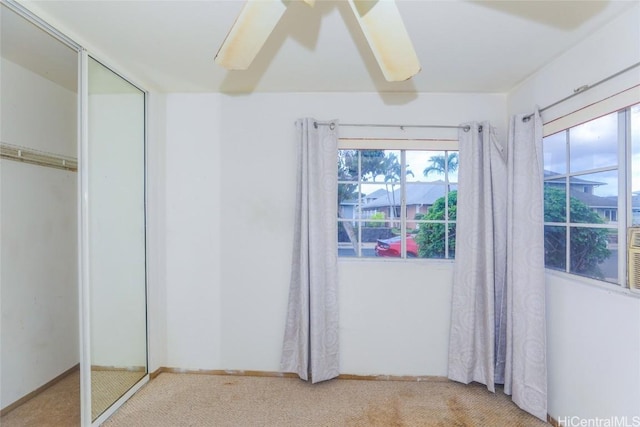 unfurnished bedroom featuring carpet flooring, ceiling fan, and a closet