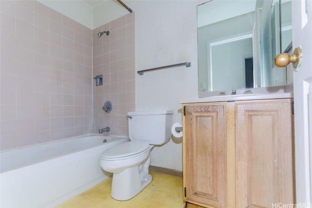 full bathroom featuring tiled shower / bath, vanity, and toilet