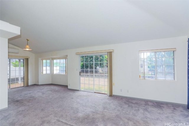 empty room with light carpet, a wall mounted air conditioner, and lofted ceiling