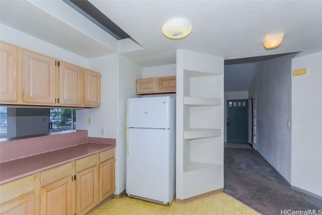 kitchen with light brown cabinetry and white refrigerator