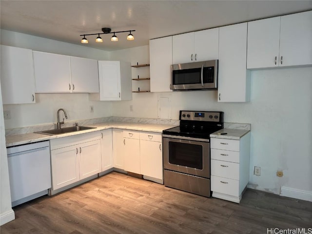 kitchen with light wood-type flooring, stainless steel appliances, sink, and white cabinets