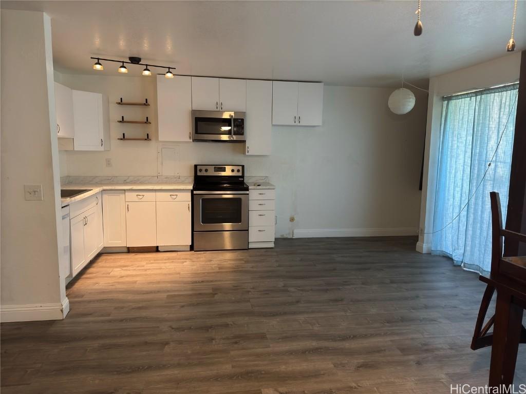 kitchen featuring white cabinetry, stainless steel appliances, and dark wood-type flooring