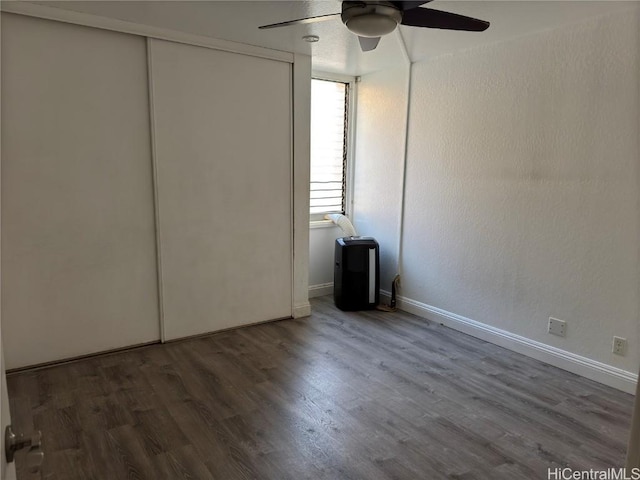 unfurnished bedroom featuring ceiling fan, dark hardwood / wood-style flooring, and a closet