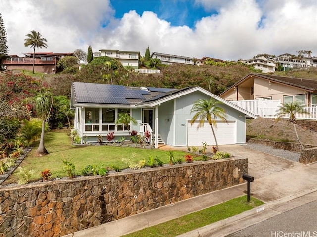 ranch-style house featuring a garage, a front lawn, and solar panels