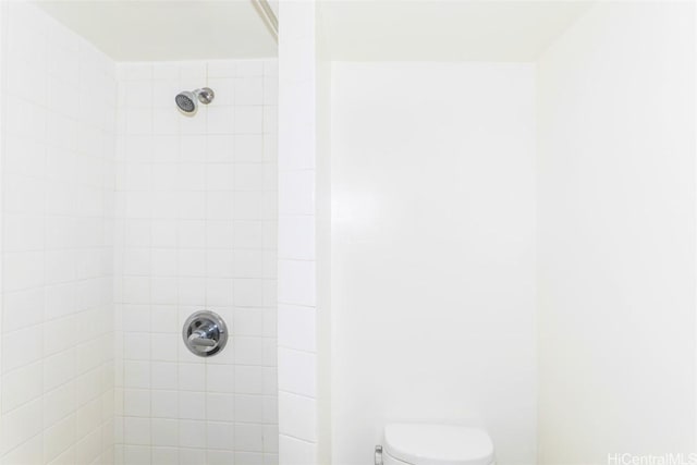 bathroom featuring toilet and tiled shower