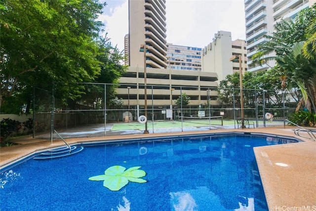 view of swimming pool with tennis court