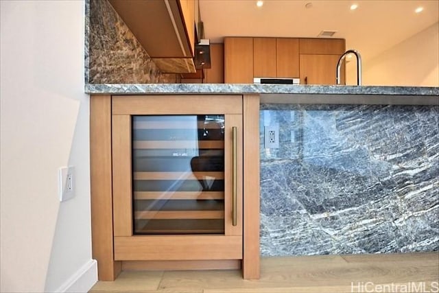 bar with wine cooler and stone counters