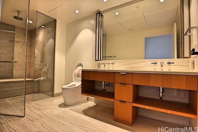 bathroom with a shower with door, vanity, hardwood / wood-style floors, and toilet