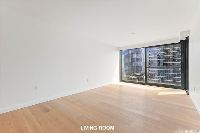 unfurnished room with light wood-style flooring and baseboards