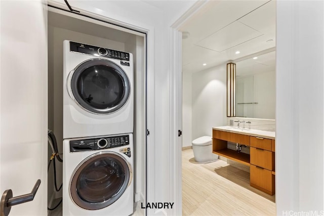 laundry room with light wood finished floors, laundry area, and stacked washer / dryer