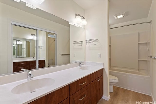 full bathroom featuring wood-type flooring, shower / bathing tub combination, vanity, and toilet