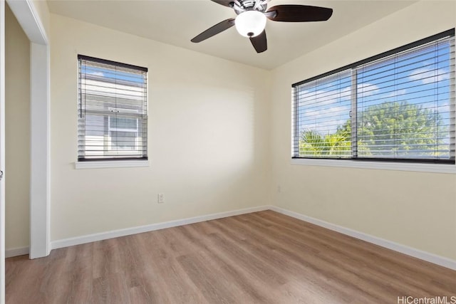 empty room with ceiling fan and light hardwood / wood-style flooring