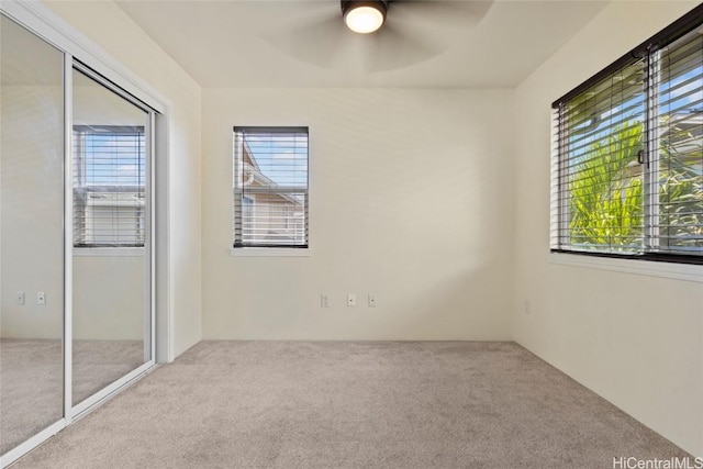 unfurnished bedroom featuring carpet floors, ceiling fan, and a closet