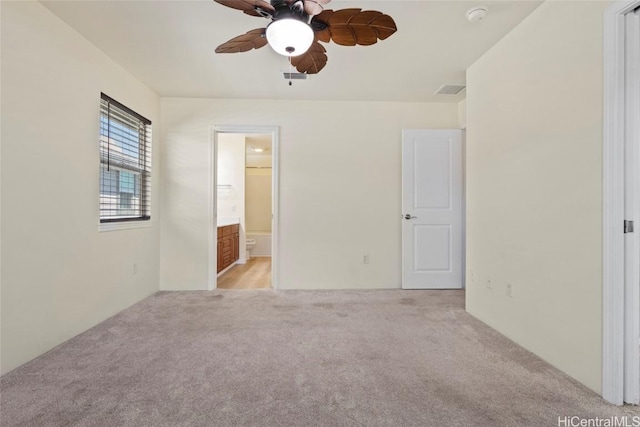 spare room featuring ceiling fan and light colored carpet