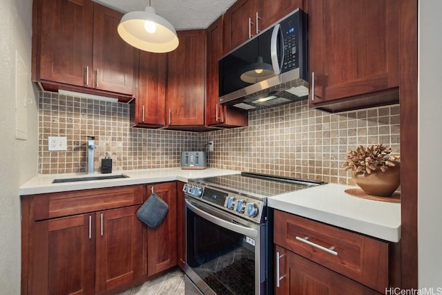 kitchen with stainless steel appliances, tasteful backsplash, hanging light fixtures, and sink