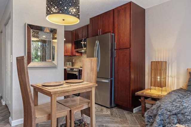 kitchen featuring parquet floors, decorative backsplash, and appliances with stainless steel finishes