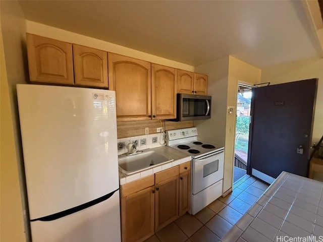 kitchen with sink, tile countertops, light tile patterned floors, white appliances, and decorative backsplash