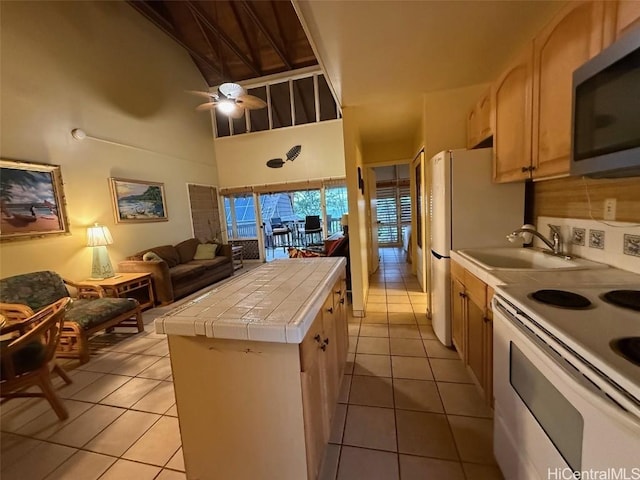 kitchen featuring light brown cabinetry, white range with electric stovetop, sink, tile counters, and ceiling fan