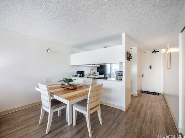 dining room with wood-type flooring and a textured ceiling