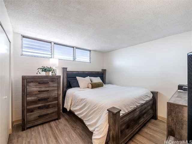 bedroom featuring a textured ceiling and light wood-type flooring