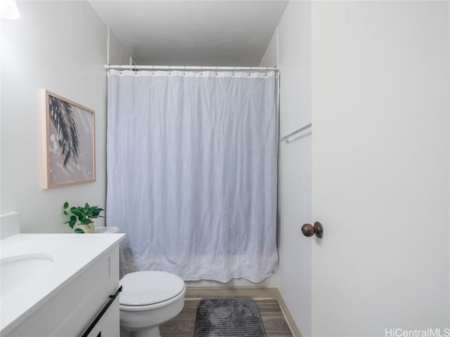 full bathroom featuring shower / bathtub combination with curtain, vanity, toilet, and hardwood / wood-style floors