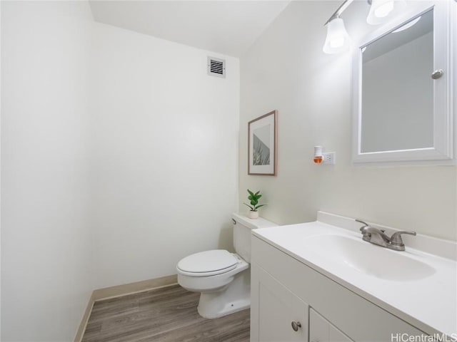 bathroom with vanity, hardwood / wood-style flooring, and toilet