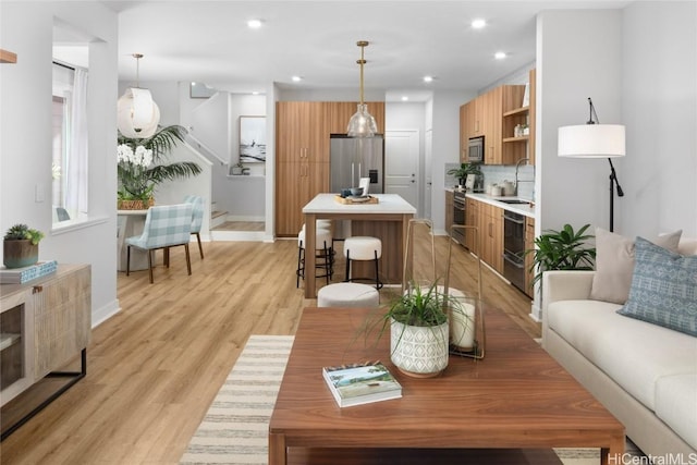 living room featuring sink and light hardwood / wood-style floors