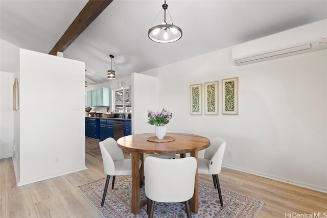 dining space with beam ceiling, a wall unit AC, and light hardwood / wood-style flooring