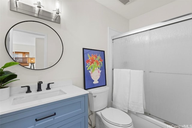 full bathroom with bath / shower combo with glass door, vanity, and toilet