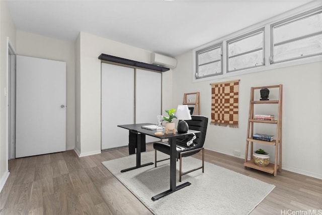 office space featuring hardwood / wood-style flooring and a wall unit AC