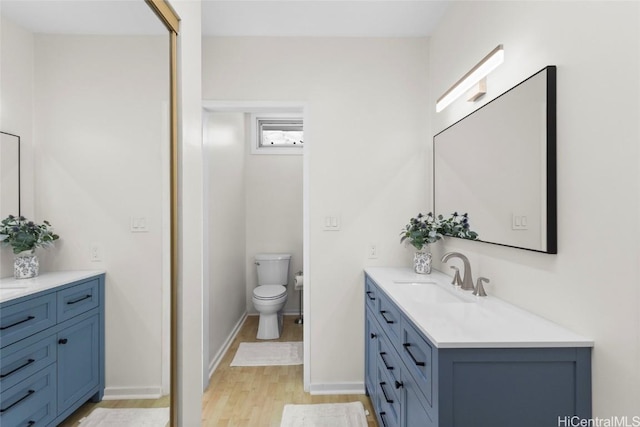 bathroom featuring hardwood / wood-style flooring, vanity, and toilet