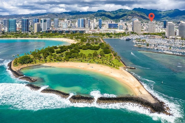 birds eye view of property with a water and mountain view and a beach view