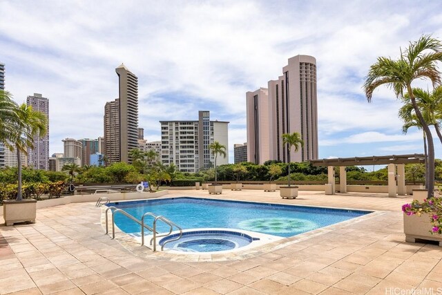 view of swimming pool with a community hot tub and a patio area