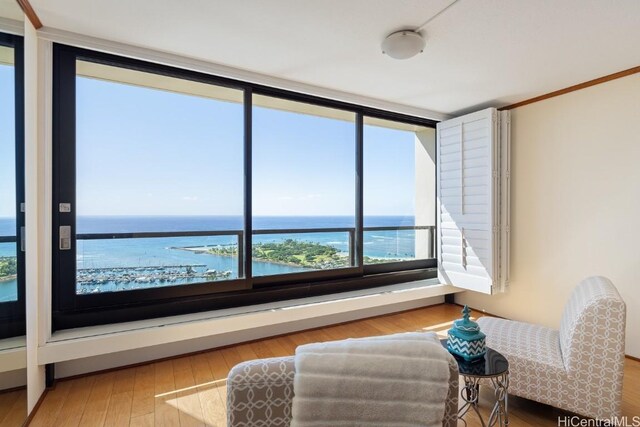 sitting room with a water view and hardwood / wood-style floors