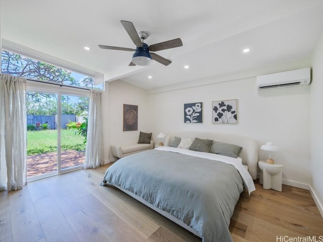 bedroom featuring a wall mounted air conditioner, light hardwood / wood-style flooring, ceiling fan, and access to exterior