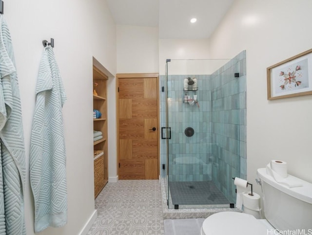 bathroom featuring a shower with shower door, tile patterned floors, and toilet