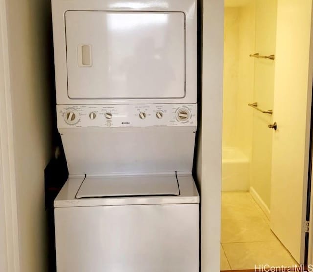 washroom featuring stacked washer and dryer and light tile patterned floors