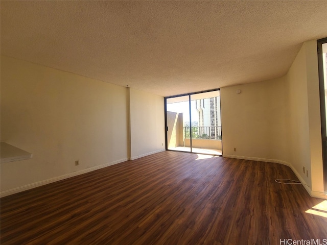 empty room with dark wood-type flooring, floor to ceiling windows, baseboards, and a textured ceiling