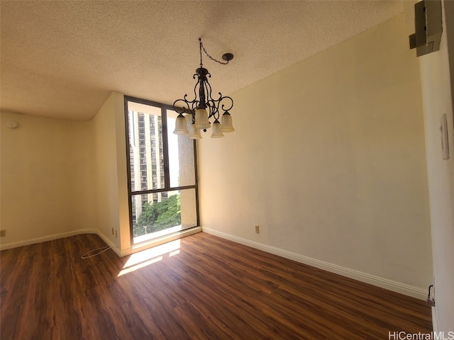 unfurnished dining area featuring a wall of windows, dark wood-style floors, baseboards, a textured ceiling, and a chandelier