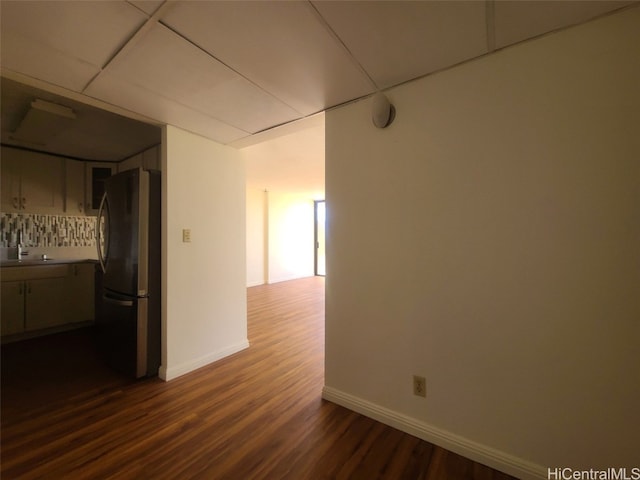 interior space with dark wood-style flooring, baseboards, and a sink