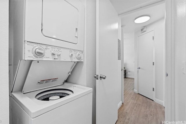 clothes washing area with stacked washer and dryer and light hardwood / wood-style floors