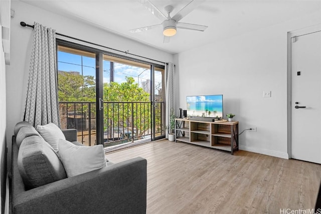 living room featuring ceiling fan and light hardwood / wood-style floors